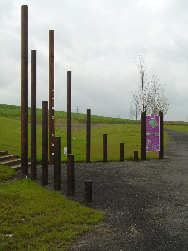 A site entrance feature consisting of a series of round posts, set in a open V formation and with Welcome text to decorate the posts