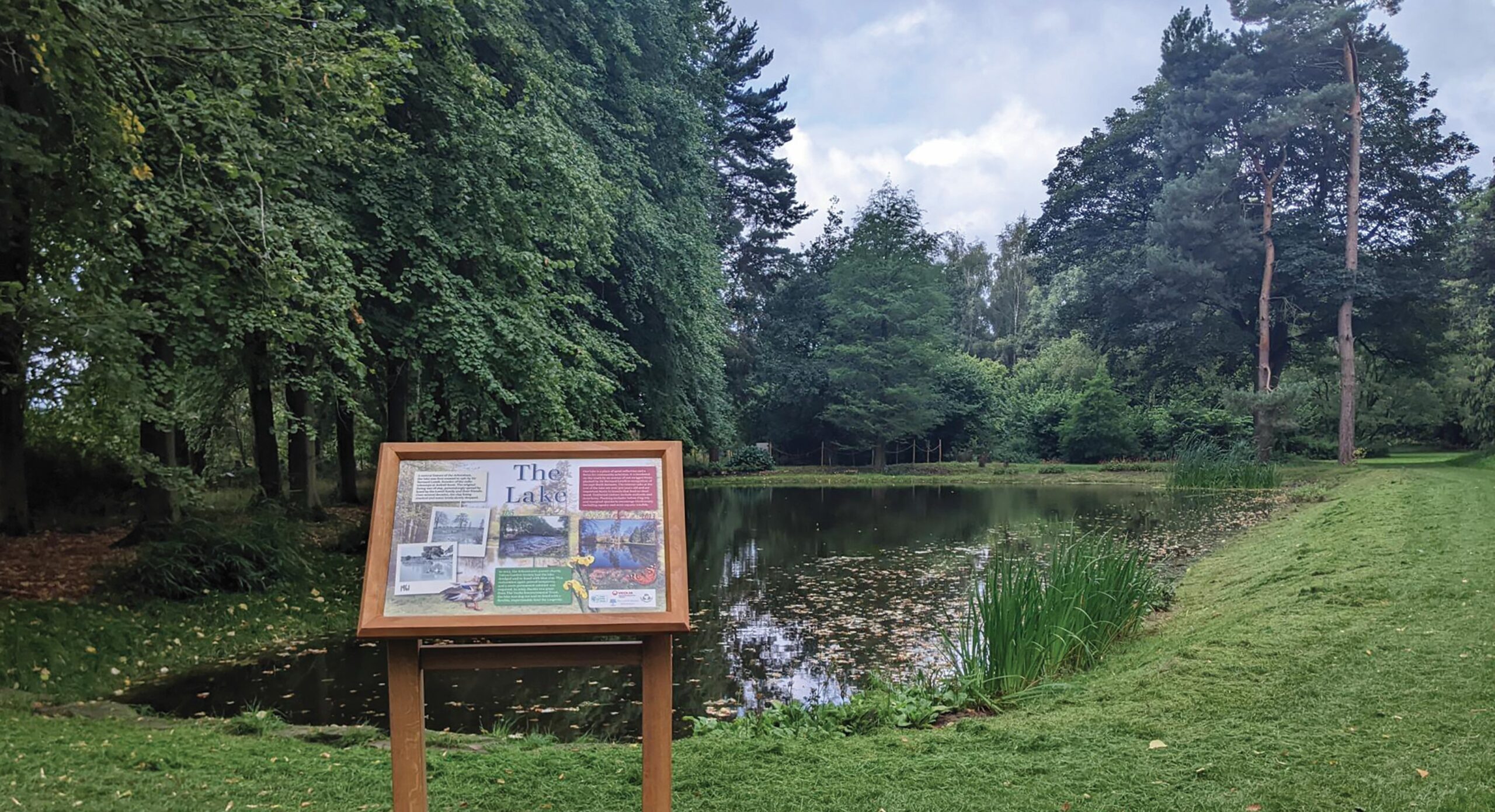 timber wildlife interpretation board next to a lake
