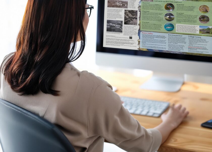 lady designing an interpretation panel on a computer
